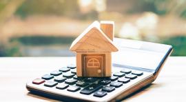 Maison en bois posée sur une calculatrice