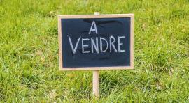 Panneau "À vendre" pour illustrer l'achat d'un terrain à bâtir