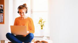 Jeune fille avec un casque sur les oreilles et devant un ordinateur