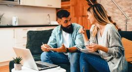 Photo d'un couple homme/femme en discussion devant un ordinateur