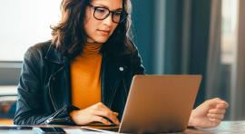 Une femme portant des lunettes qui regarde quelque chose sur son ordinateur 