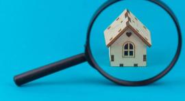 Loupe qui est posée devant une maquette de maison