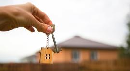 Photo d'un porte clé avec une maison en bois et une clé 