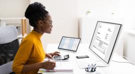 Photo d'une femme devant un ordinateur avec une calculatrice pour revendre ses parts de SCPI de plus value