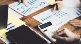 personnes devant des graphiques sur une table de réunion