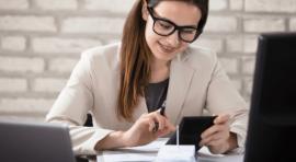 Femme avec sa calculette devant un ordinateur