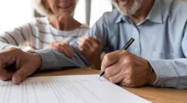 Seniors en train de signer un document d'investissement en assurance vie