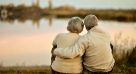 Photo d'un couple de seniors assis au bord de l'eau ayant préparé leur assurance vie