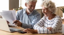Couple senior homme/femme devant un ordinateur et un contrat d'assurance vie