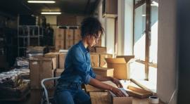 Femme en train d'emballer des choses dans un carton 