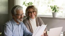 Couple homme/femme en train de lire un document pour investir à 50 ans