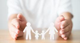 Photo de mains qui encadrent l'image d'une famille avec 2 enfants