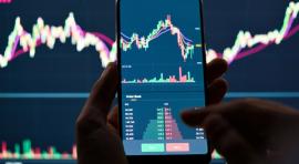 Photo d'un homme avec Smartphone affichant un graphique de bourse à l'écran illustrant un OPCVM