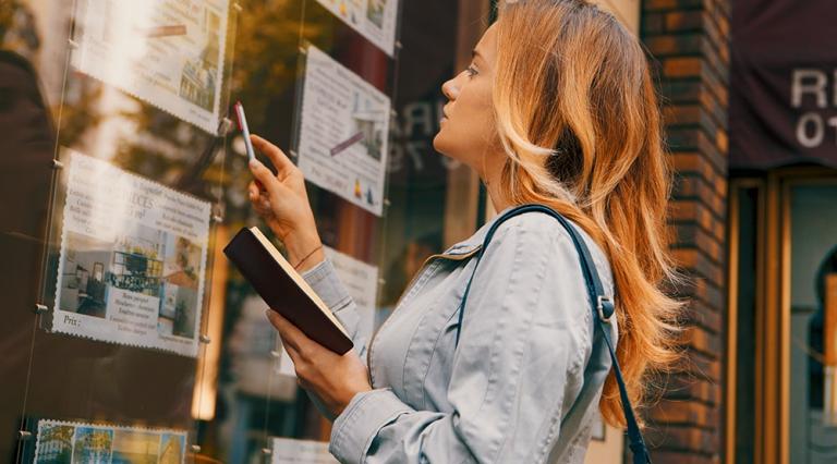 femme devant une agence immobilière