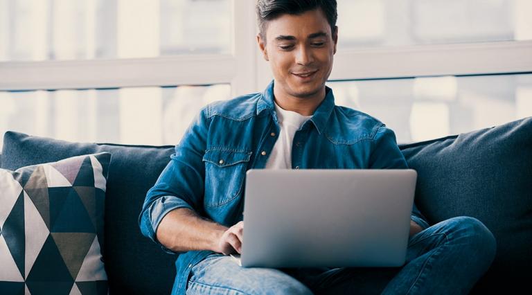 homme sur son canapé avec un ordinateur portable