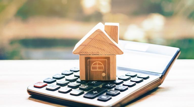 Maison en bois posée sur une calculatrice