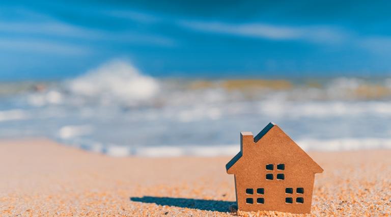 Petite maison sur une plage pour illustrer l'achat immobilier en bord de mer