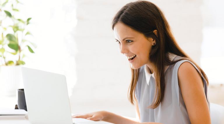 Femme souriante devant un ordinateur