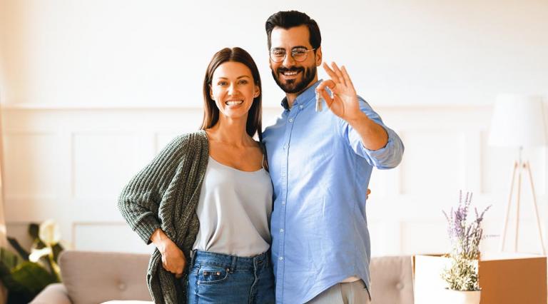 couple dans un salon présentant des clés synonyme d'achat