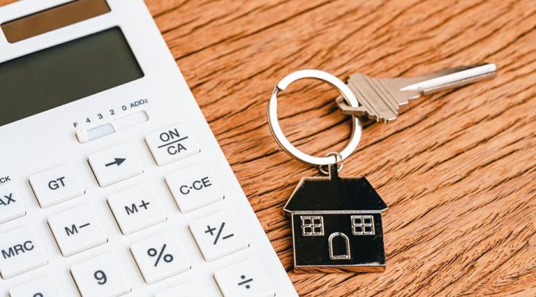 Photo d'un trousseau de clés avec une maison à côté d'une calculatrice