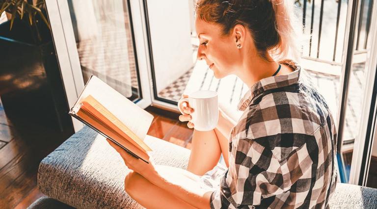 Photo d'une femme en train de lire dans son salon