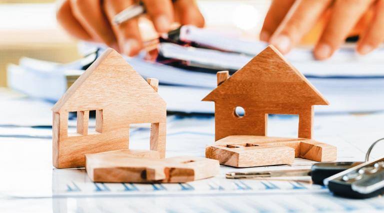 Photo d'une maquette de maison posée devant des clés