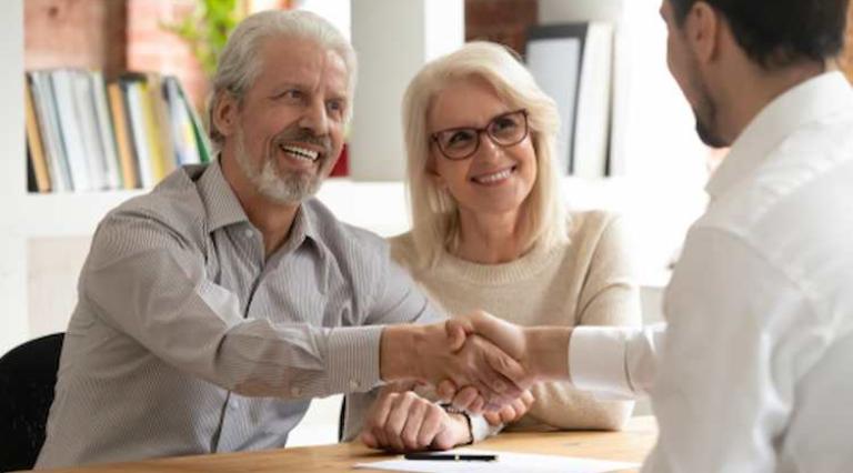 Couple homme/femme de seniors serrant la main à un conseiller