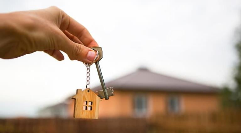 Photo d'un porte clé avec une maison en bois et une clé 