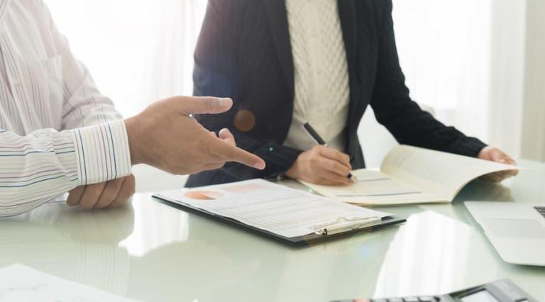 Personnes autour d'une table avec des contrats Pinel Plus