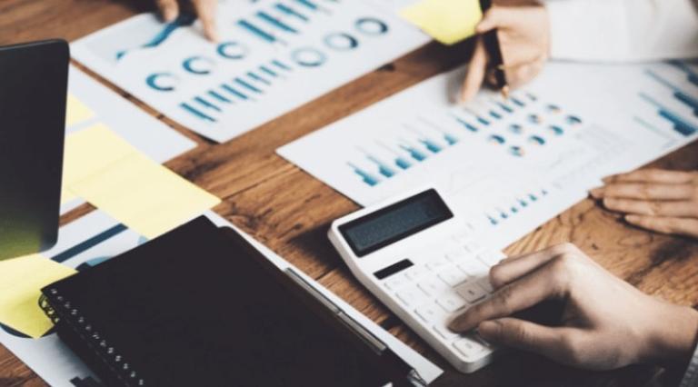 personnes devant des graphiques sur une table de réunion