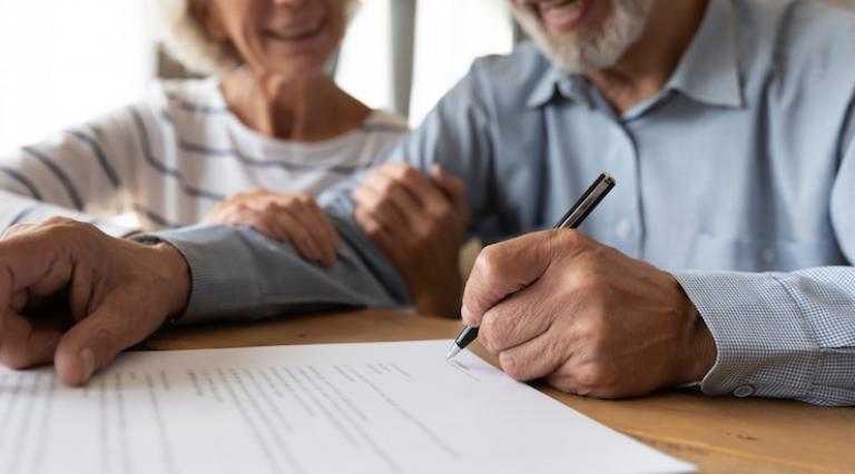 Seniors en train de signer un document d'investissement en assurance vie