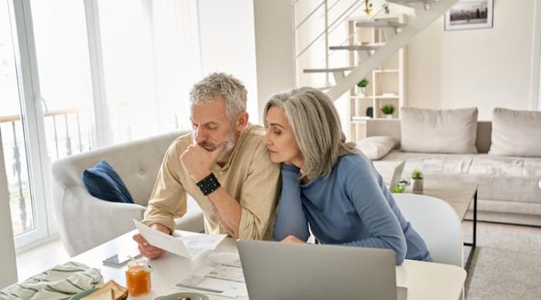 Couple senior homme/femme devant un ordinateur pour débloquer PER en anticipé