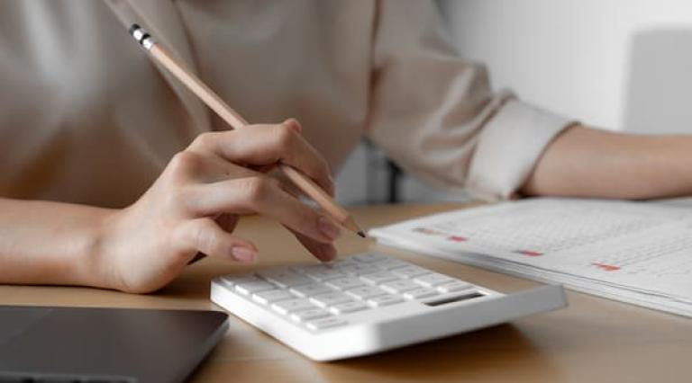 Mains sur une calculatrice et une liste à checker avant de signer un PER