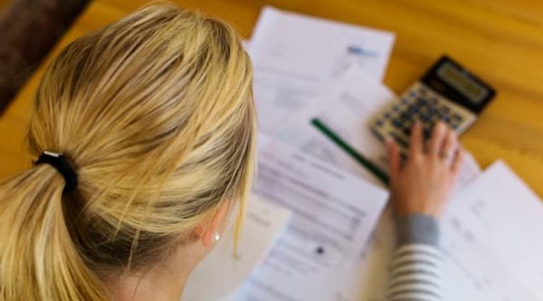 Femme devant des papiers concernant le PEA et une calculatrice