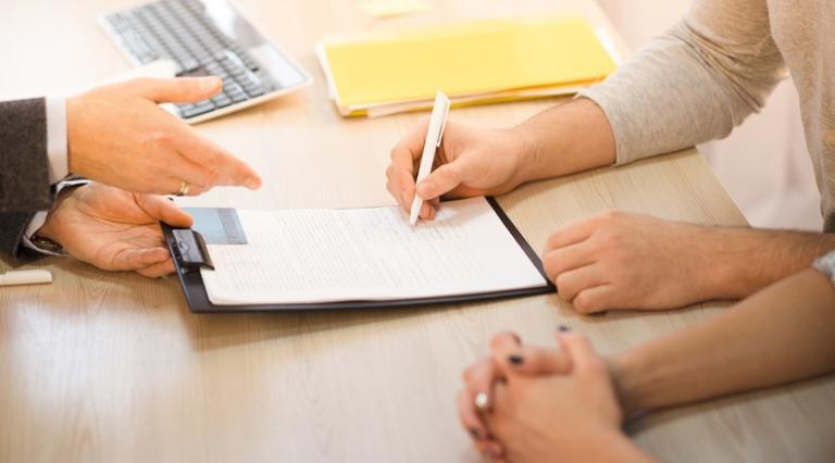 Photo de mains en train de signer un contrat d'épargne