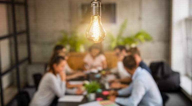 Plusieurs personnes assises autour d'une table pour un echanger sur investir dans une startup avec anaxago