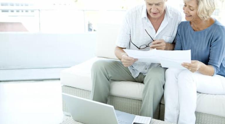 Couple senior homme/femme devant des documents pour investir a la retraite
