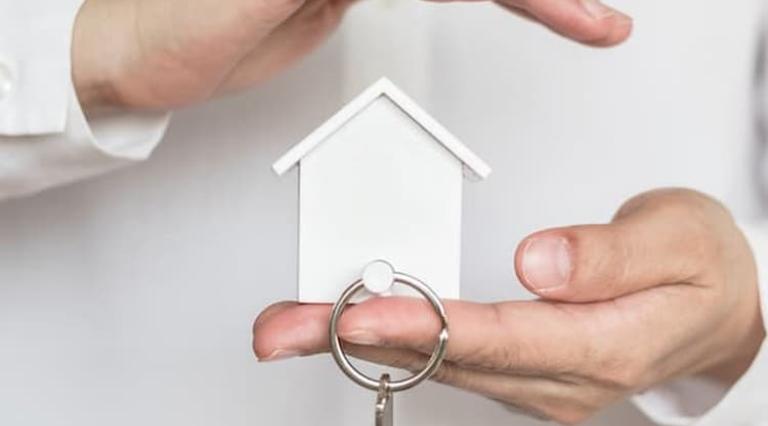 Photo de mains tenant un porte-clés avec une maison illustrant l investissement locatif cle en main