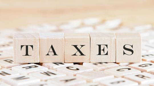 Cubes de lettres formant le mot « taxes » pour illustrer les nouveaux barèmes des impôts 2021