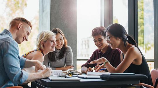 Photo d'un groupe d'étudiants autour d'une table en train de travailler