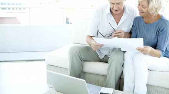 Couple senior homme/femme devant des documents pour investir a la retraite