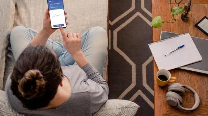 Femme en train de consulter son smartphone pour investir en crowdfunding immobilier