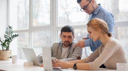 3 personnes devant un ordinateur concentrées sur un projet de crowdfunding immobilier