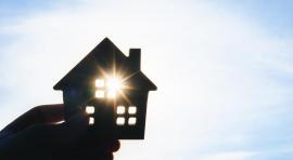 Photo d'une main qui tient une maquette de maison
