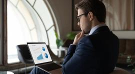 Homme assis devant un ordinateur se posant 5 questions avant d investir en crowdfunding immobilier