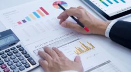 Mains sur une calculatrice et devant des graphiques d'investissement revalorisation SCPI de rendement