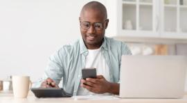 Homme avec un téléphone à la main et une calculatrice à côté analysant son LEP