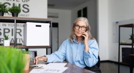 Femme au telephone devant des documents d'epargne
