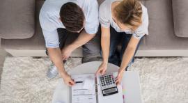Couple homme/femme devant un dossier d epargne et une calculatrice