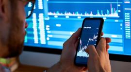 homme avec Smartphone affichant un graphique de bourse à l'écran pour investir 1000 euros
